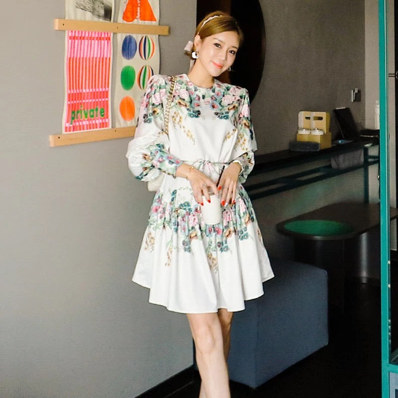 a woman wearing white floral print skater dress with belt