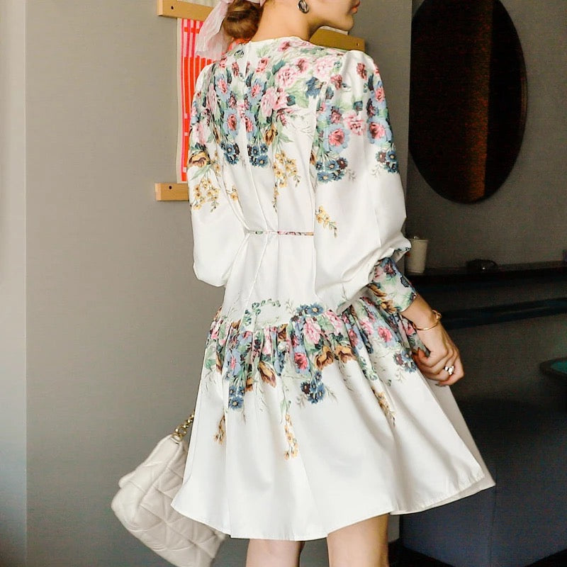 a woman wearing white floral print skater dress with belt