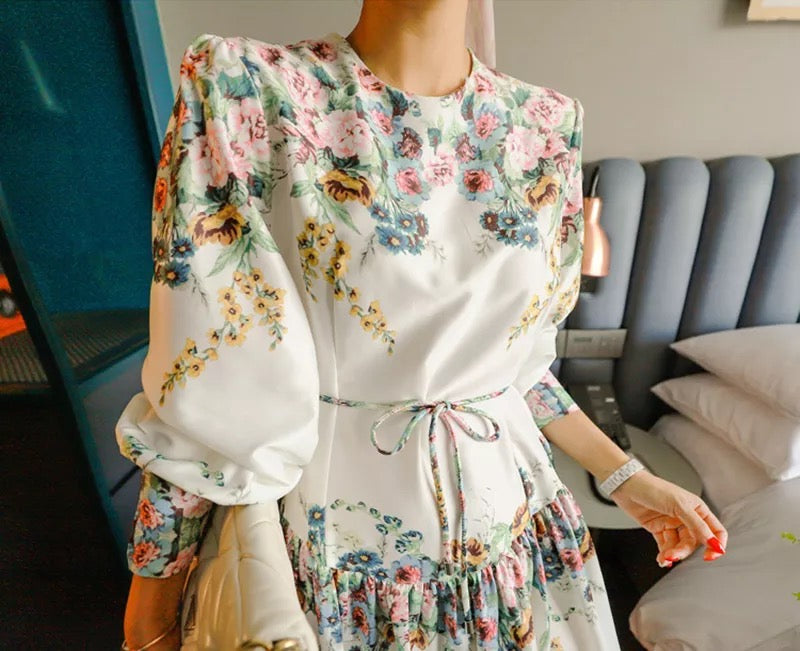 a woman wearing white floral print skater dress with belt
