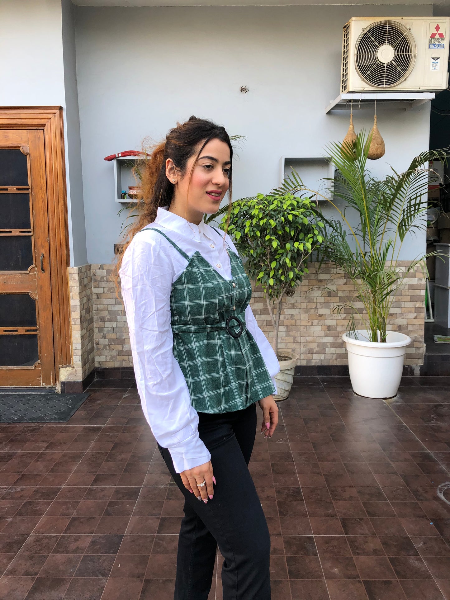a woman wearing turquoise checked top with polo collar