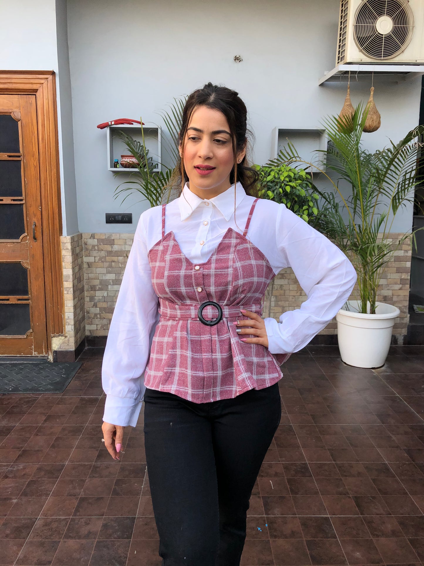a woman wearing pink checked top with polo collar