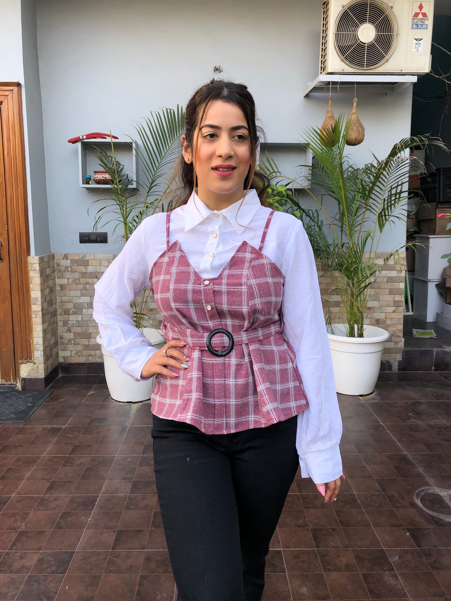 a woman wearing pink checked top with polo collar