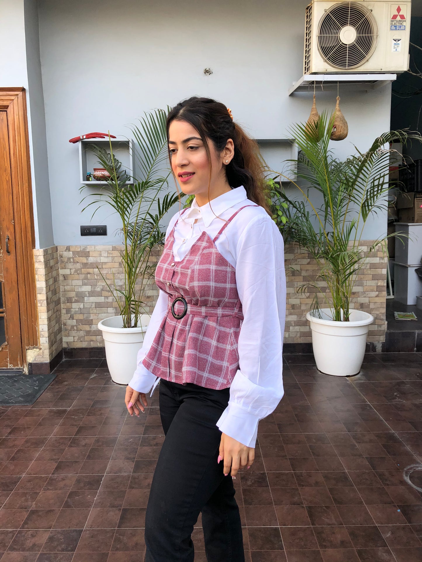 a woman wearing pink checked top with polo collar