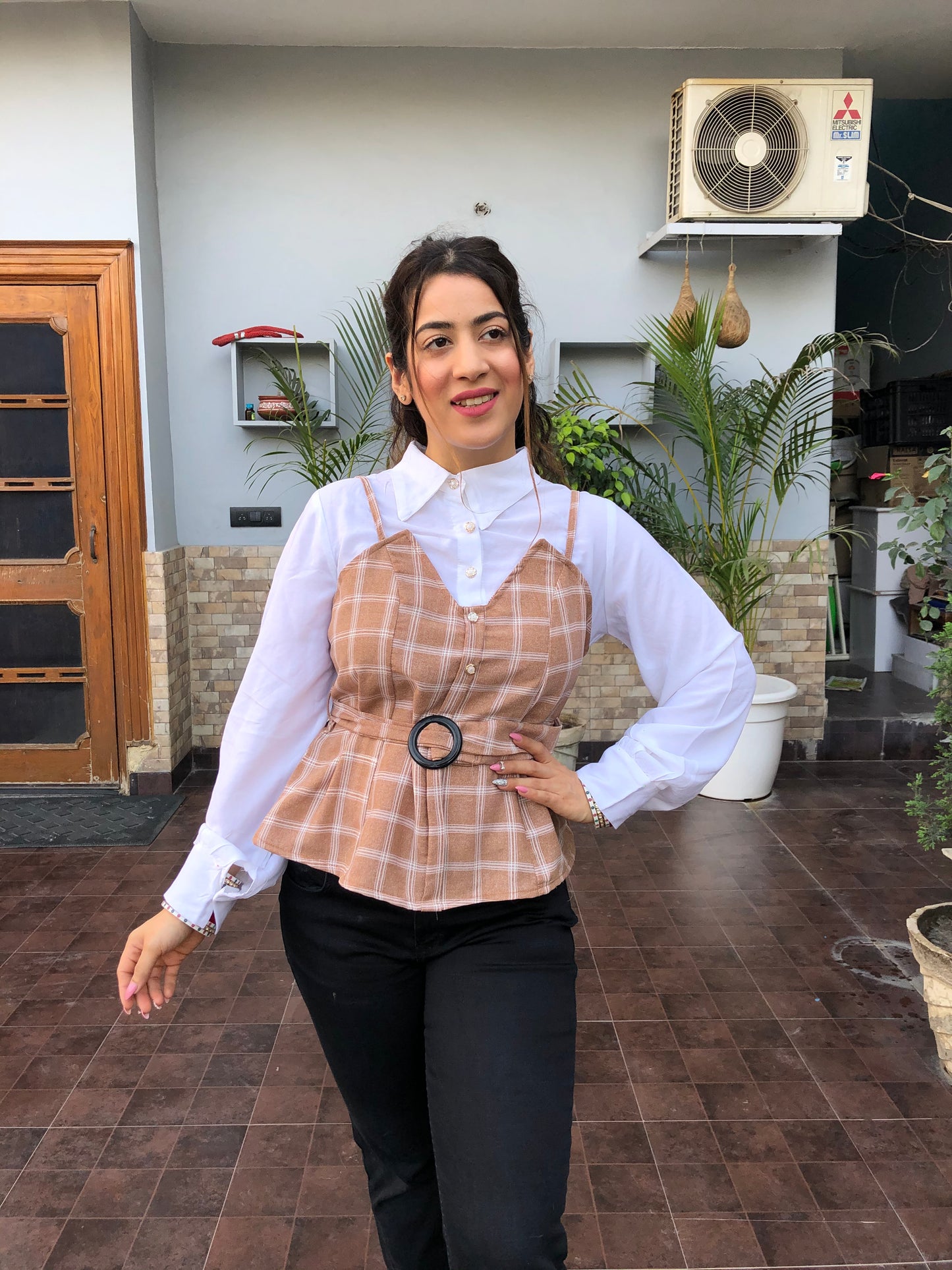 a woman wearing brown checked top with polo collar