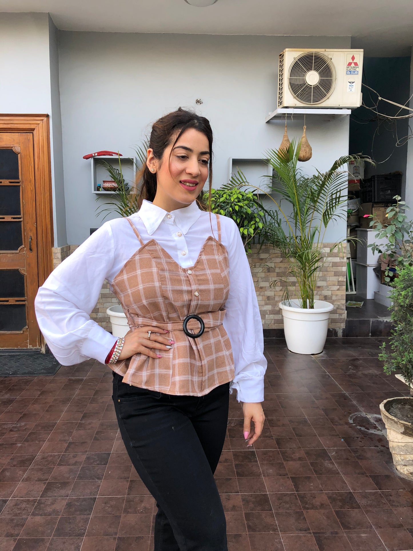 a woman wearing brown checked top with polo collar