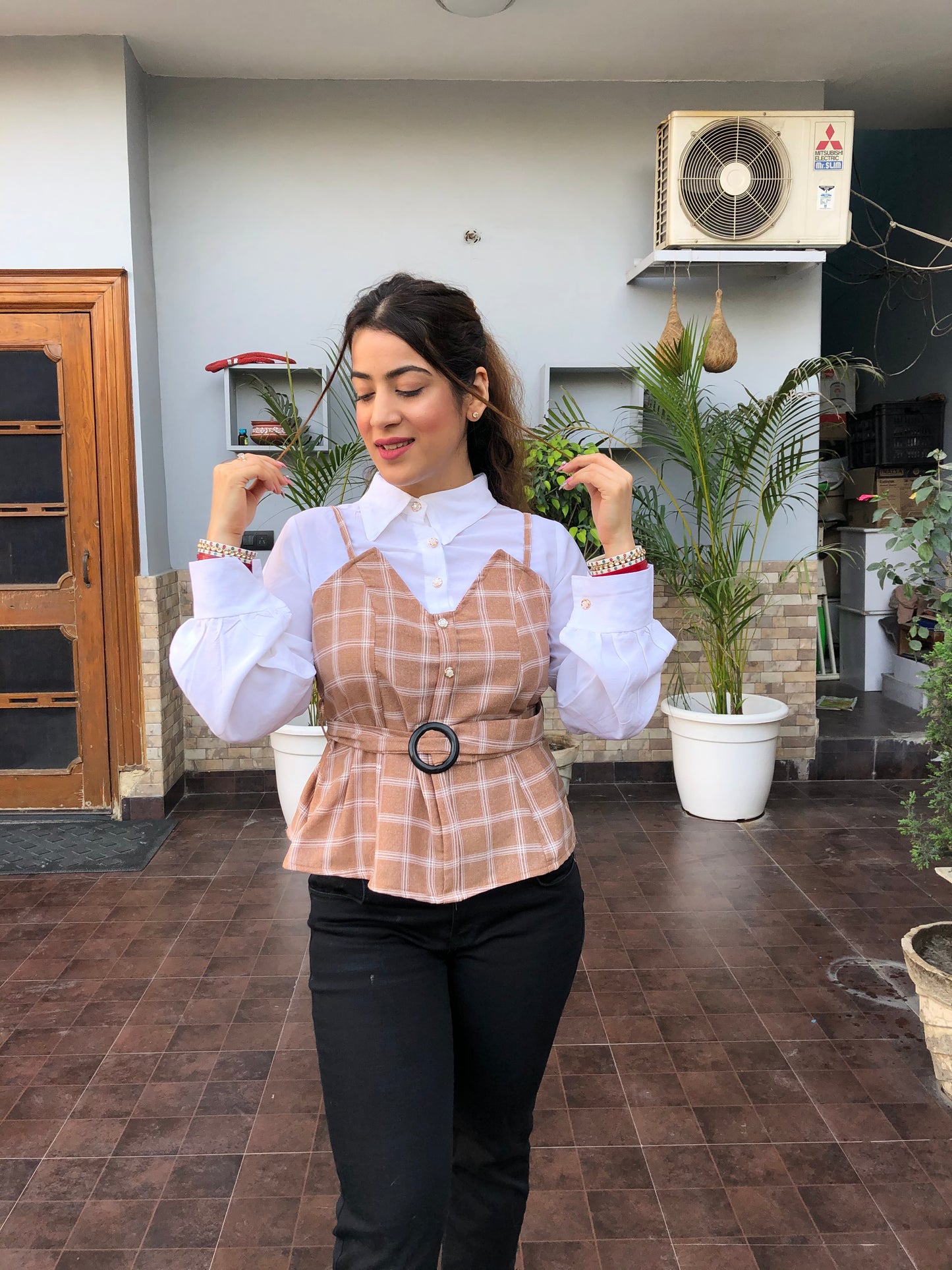 a woman wearing brown checked top with polo collar