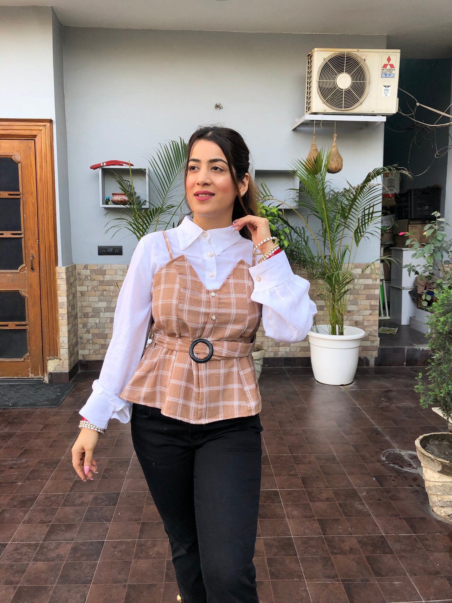 a woman wearing brown checked top with polo collar