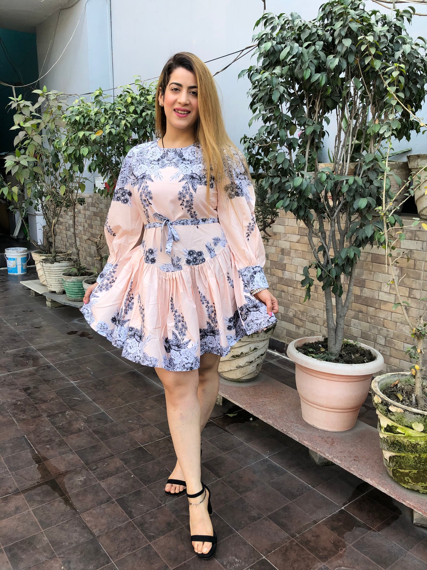 a woman wearing peach floral skater dress