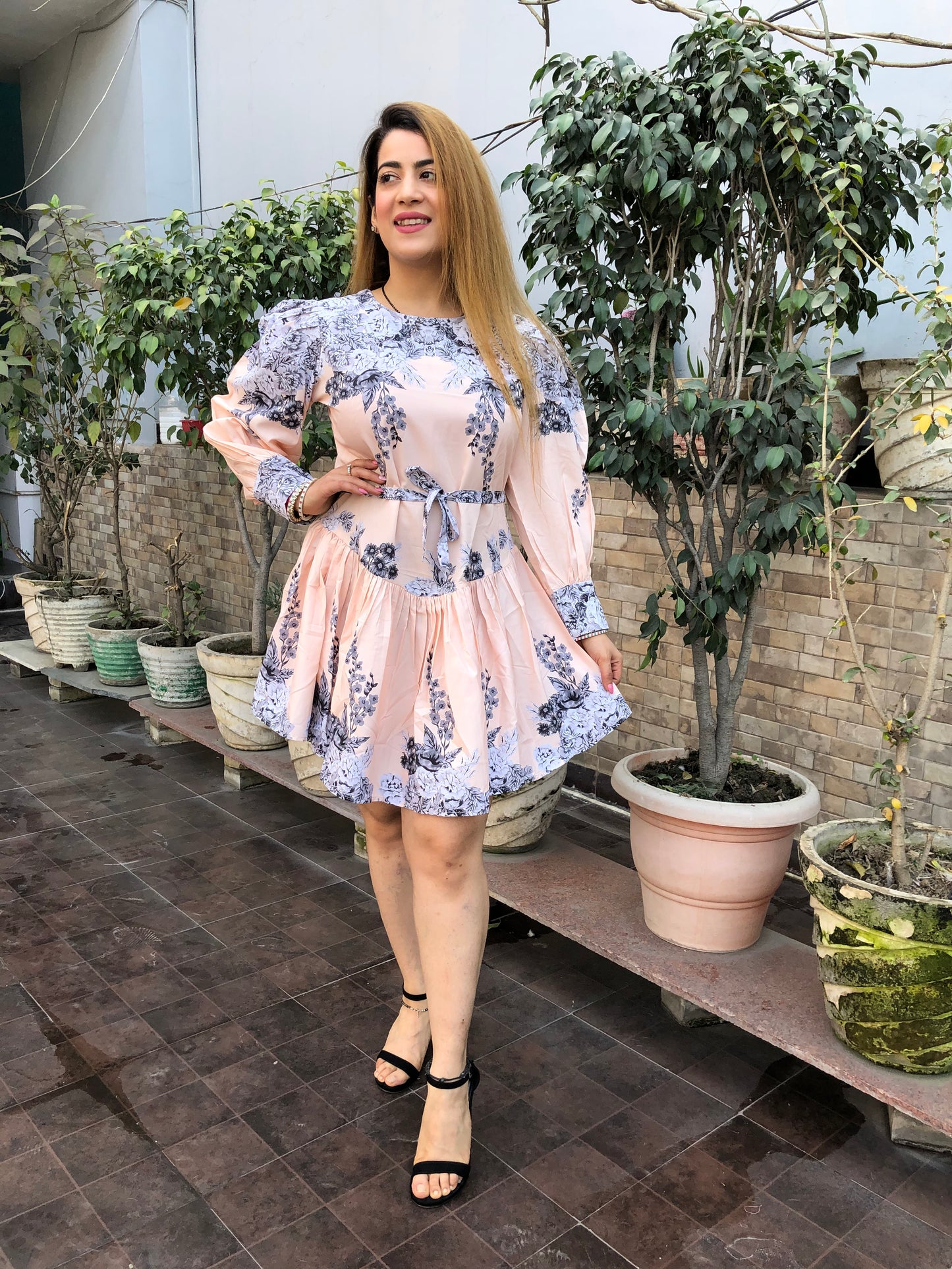 a woman wearing peach floral skater dress